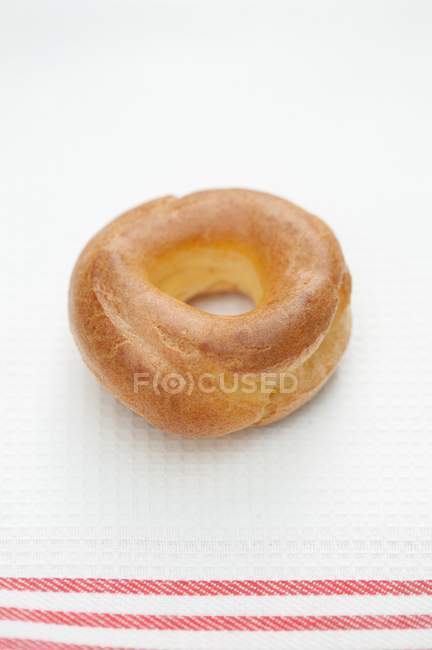 Vista de primer plano del anillo de pastelería choux en la superficie blanca - foto de stock