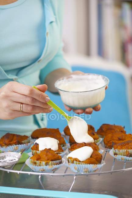 Woman spreading glace icing — Stock Photo