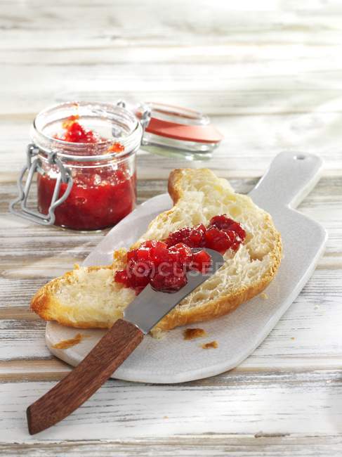 Ein halbes Croissant mit Erdbeermarmelade — Stockfoto