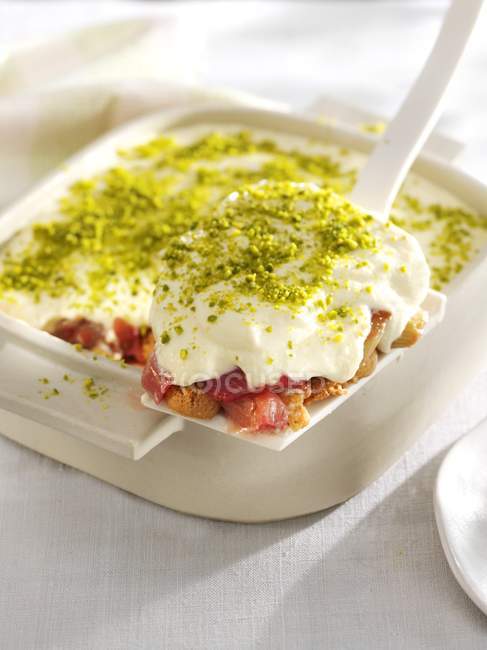 Closeup view of rhubarb bake with amaretti and cream — Stock Photo