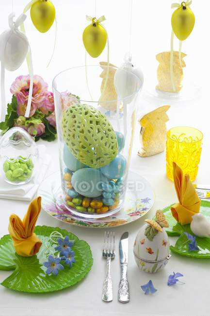 Стол накрыт пасхальными украшениями и красочными сладостями — стоковое фото