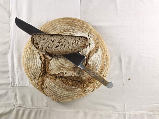 Brown loaf with knife — Stock Photo