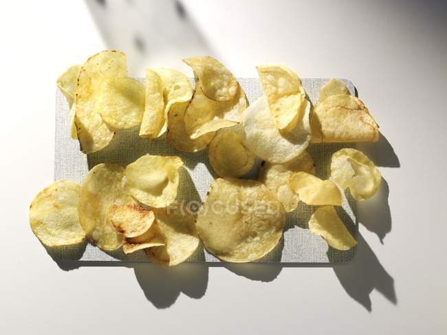 Картопляні чіпси на обробній дошці — стокове фото
