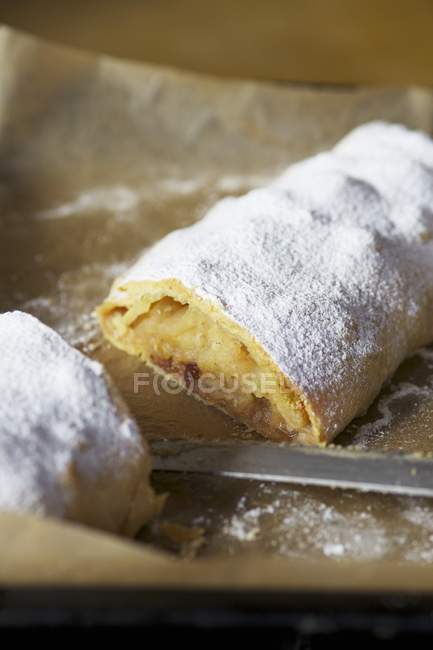 Closeup view of cut apple strudel dusted with icing sugar — Stock Photo