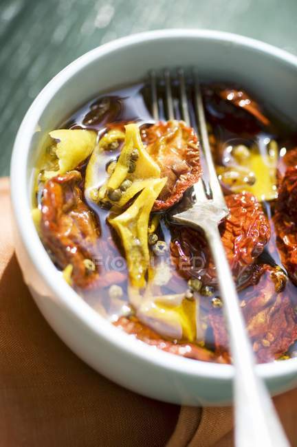 Preserved sundried tomatoes in a small bowl with fork — Stock Photo