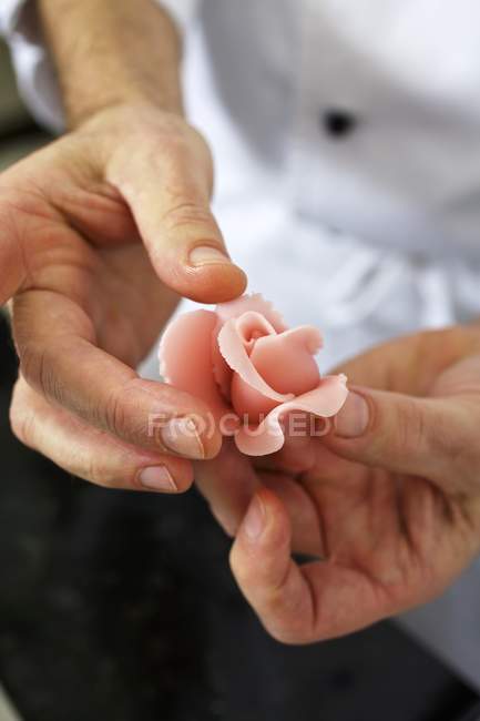 Closeup view of a confectioner shaping a marzipan rose — Stock Photo