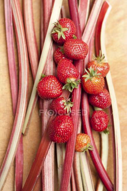 Strawberries and stalks of rhubarb — Stock Photo