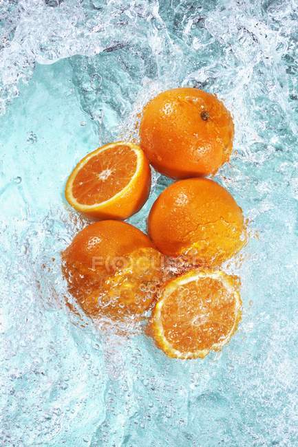 Свежие апельсины в воде — стоковое фото