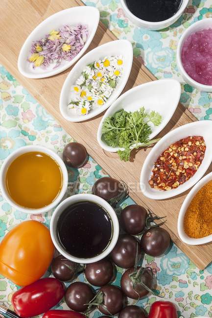 Tomatoes, sauces, herbs and spices in saucers — Stock Photo