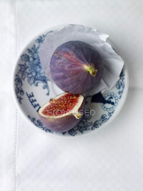Whole and halved figs on plate — Stock Photo