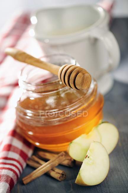 Honey with wooden dipper — Stock Photo
