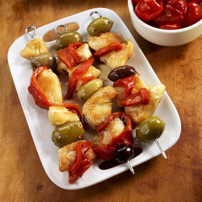 Chicken, Pepper and Olive Skewers en una fuente blanca - foto de stock