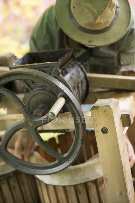 Closeup cropped view of person holding barrel by cider press — Stock Photo