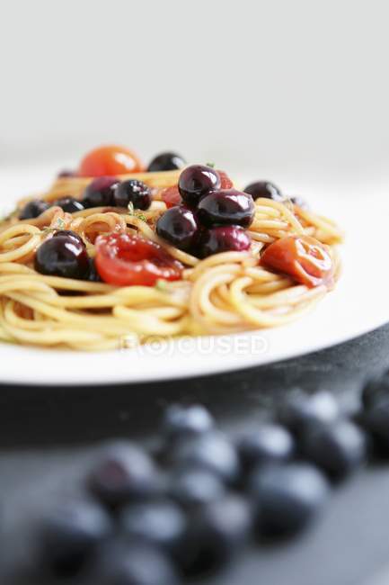 Спагетті з оливками та помідорами — стокове фото