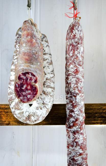 Três tipos de salame pendurado — Fotografia de Stock