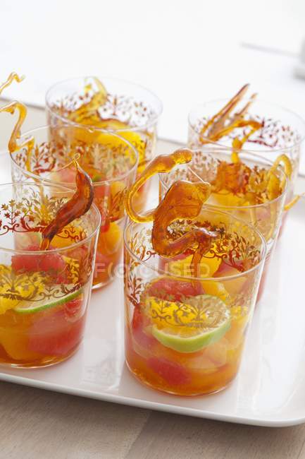 Fruit punch with sticks of caramel — Stock Photo