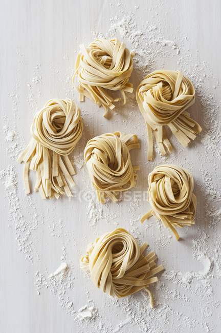 Nests of flat tagliatelle noodles — Stock Photo