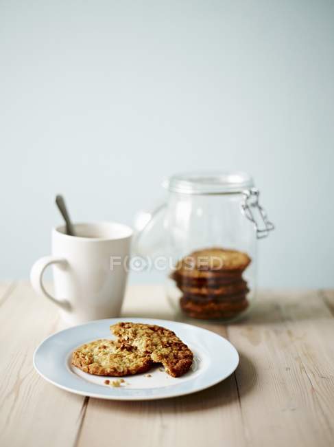 Anzac biscuits in jar and on plate — Stock Photo