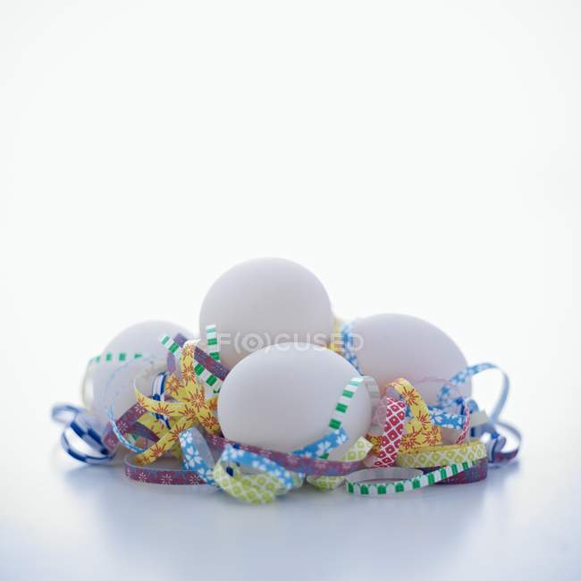 Weiße Eier mit Locken aus geschreddertem Papier — Stockfoto