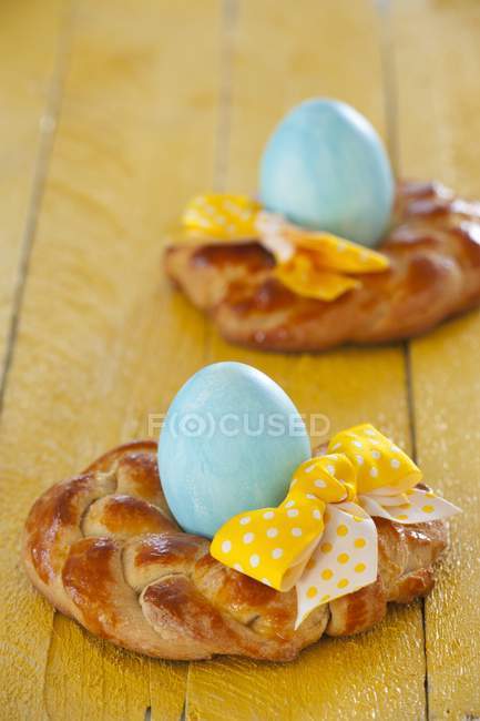 Closeup view of small Easter wreaths with colored eggs and bows — Stock Photo