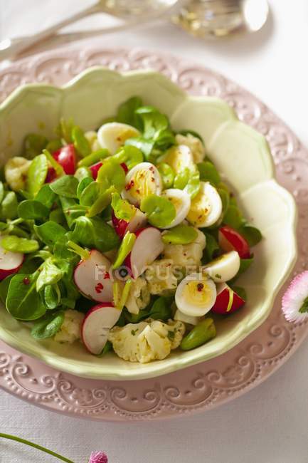 Цветной салат с перепелиными яйцами в миске — стоковое фото