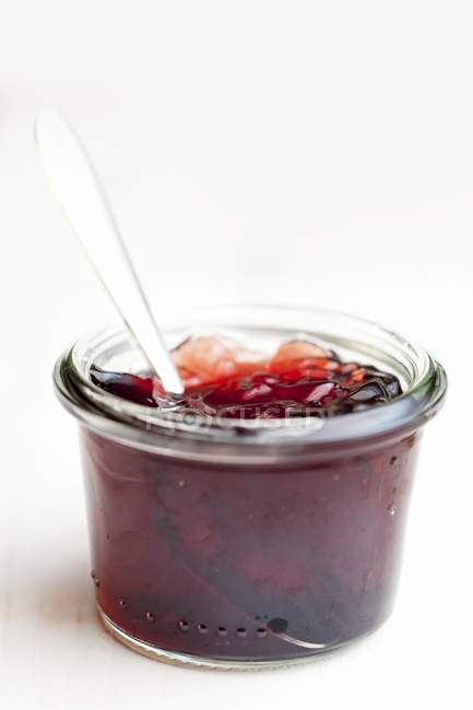 Blackcurrant jam with spoon in jar — Stock Photo
