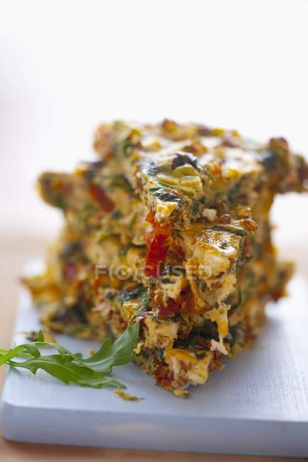 Closeup view of vegetable Frittata with spinach, leek, dried tomatoes and onions — Stock Photo