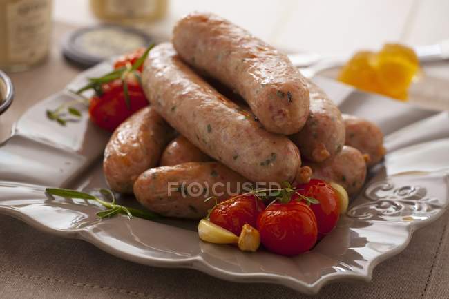 Oven-baked sausages with cherry tomatoes — Stock Photo