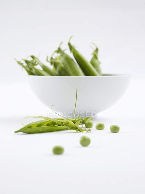Green Peas and pods in bowl — Stock Photo