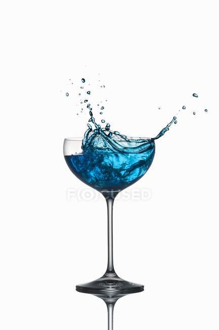Nahaufnahme von blauem Curaçao, der aus dem Glas spritzt — Stockfoto