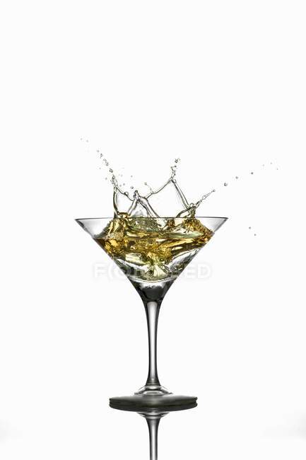 Martini splashing out of a glass — Stock Photo