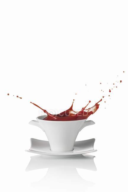 Tomato soup splashing out of soup bowl — Stock Photo