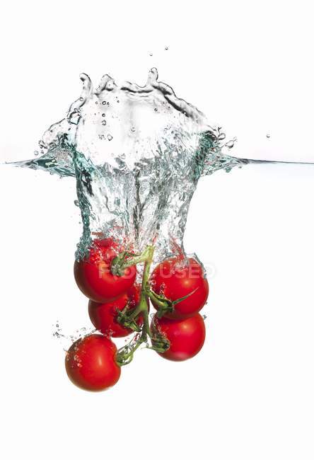 Tomates que caem na água — Fotografia de Stock