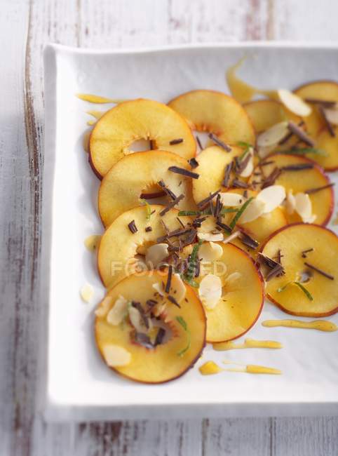 Nectarine carpaccio with almonds — Stock Photo