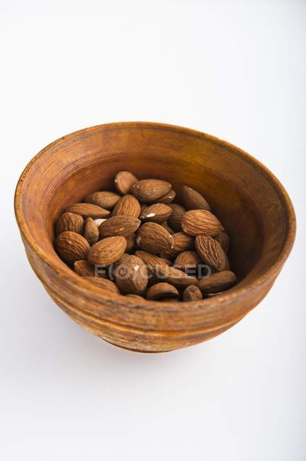 Amêndoas em prato de madeira — Fotografia de Stock