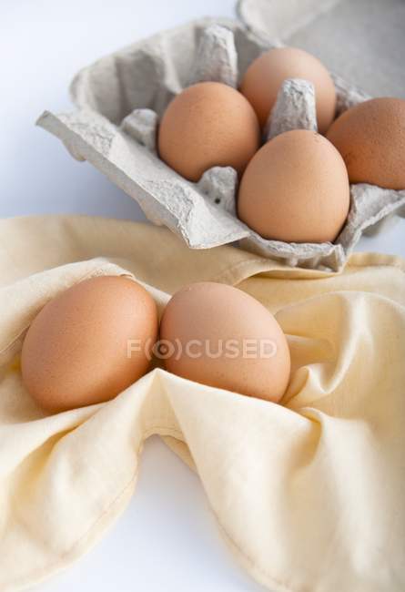 Chicken eggs on yellow fabric — Stock Photo
