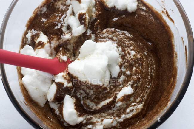 Closeup view of beaten egg whites in melted chocolate — Stock Photo