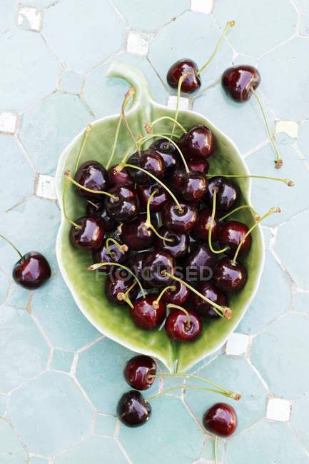 Cherries in leaf-shaped bowl — Stock Photo