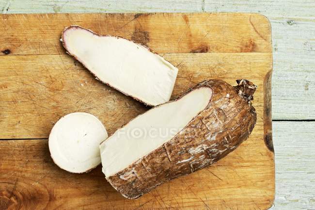 Racine de manioc, coupée ouverte, sur une planche à découper — Photo de stock