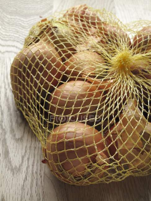 Cebollas marrones en neto - foto de stock
