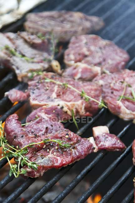 Marinated steaks on grill — Stock Photo