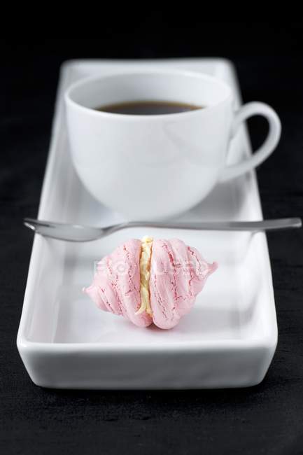 Tasse de café avec petite meringue rose — Photo de stock