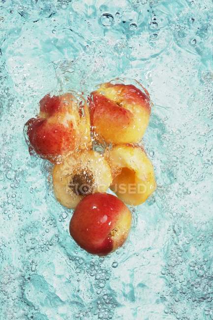 Aprikosen mit Hälften im Wasser — Stockfoto