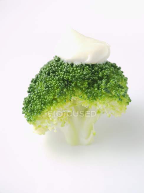 Cooked broccoli with blob of mayonnaise — Stock Photo