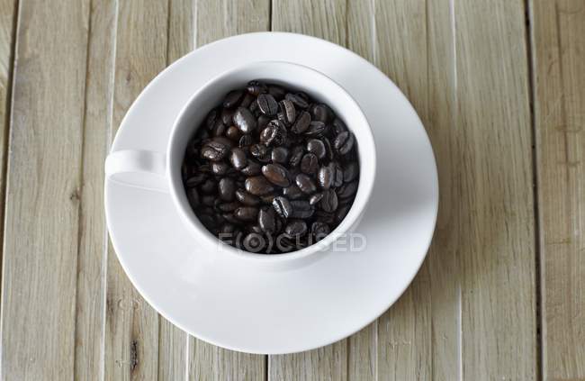 Chicchi di caffè in tazza bianca — Foto stock