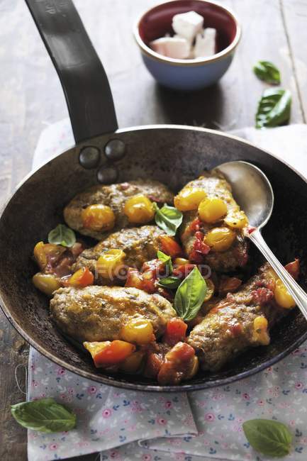 Gnocchi berenjena con tomates y albahaca en sartén con cuchara - foto de stock
