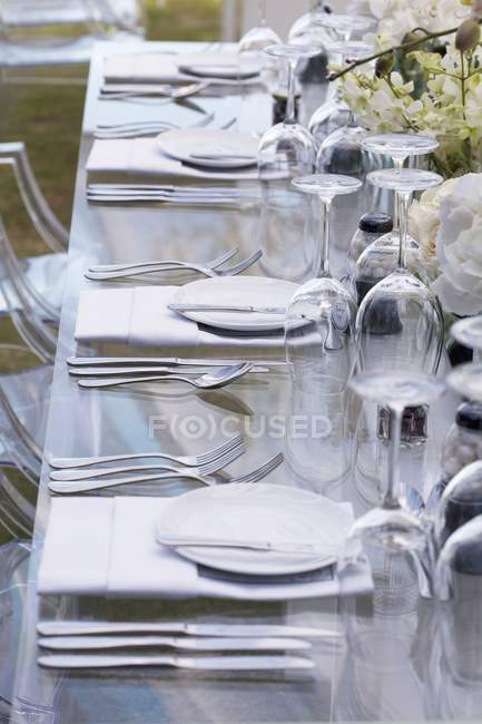 Vista elevada de una mesa colocada con flores - foto de stock