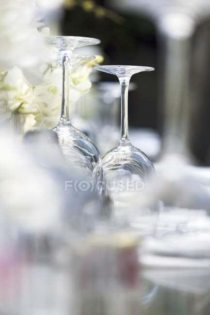 Vista close-up de copos de vinho virados para cima em uma mesa colocada — Fotografia de Stock