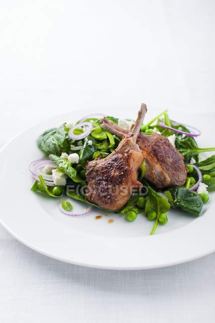 Roasted Lamb chops on spinach salad — Stock Photo