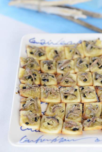 Closeup view of canapes with sardines and pieces of olive — Stock Photo